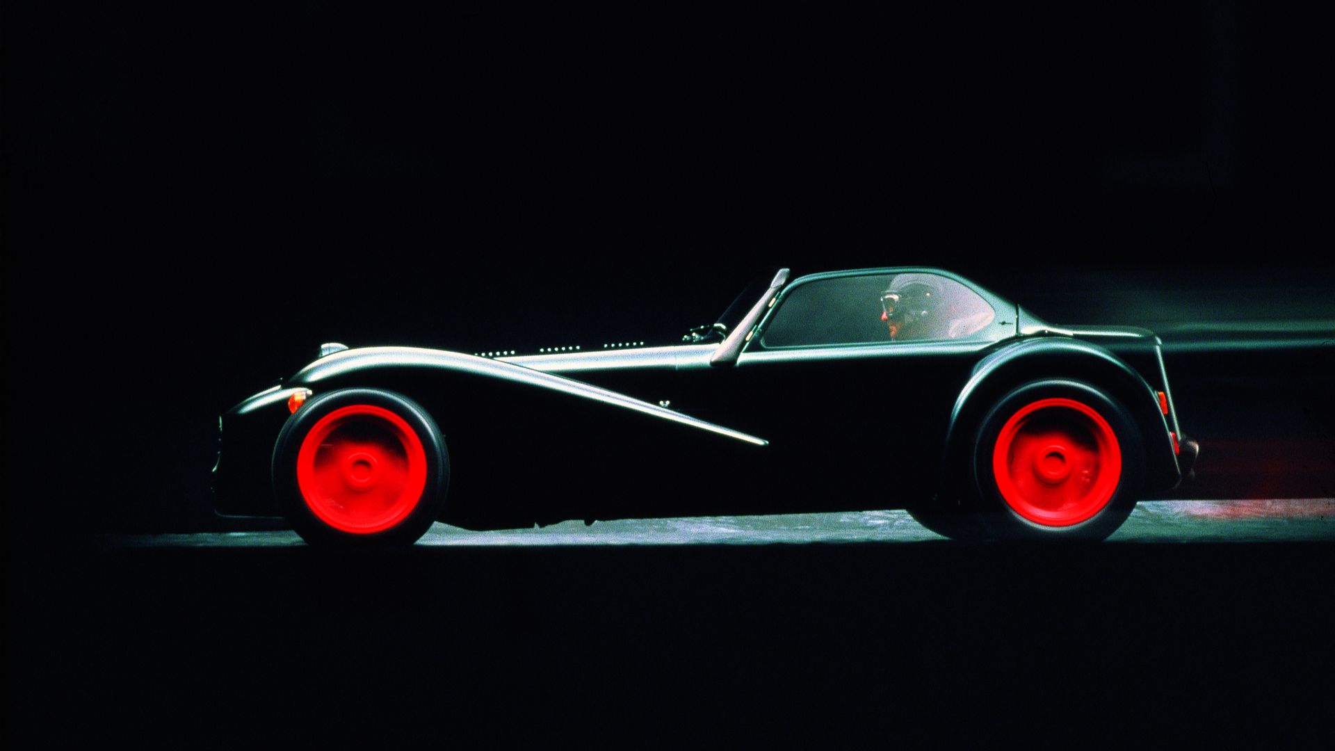 Side view of a black Donkervoort D8 Cosworth with red rims