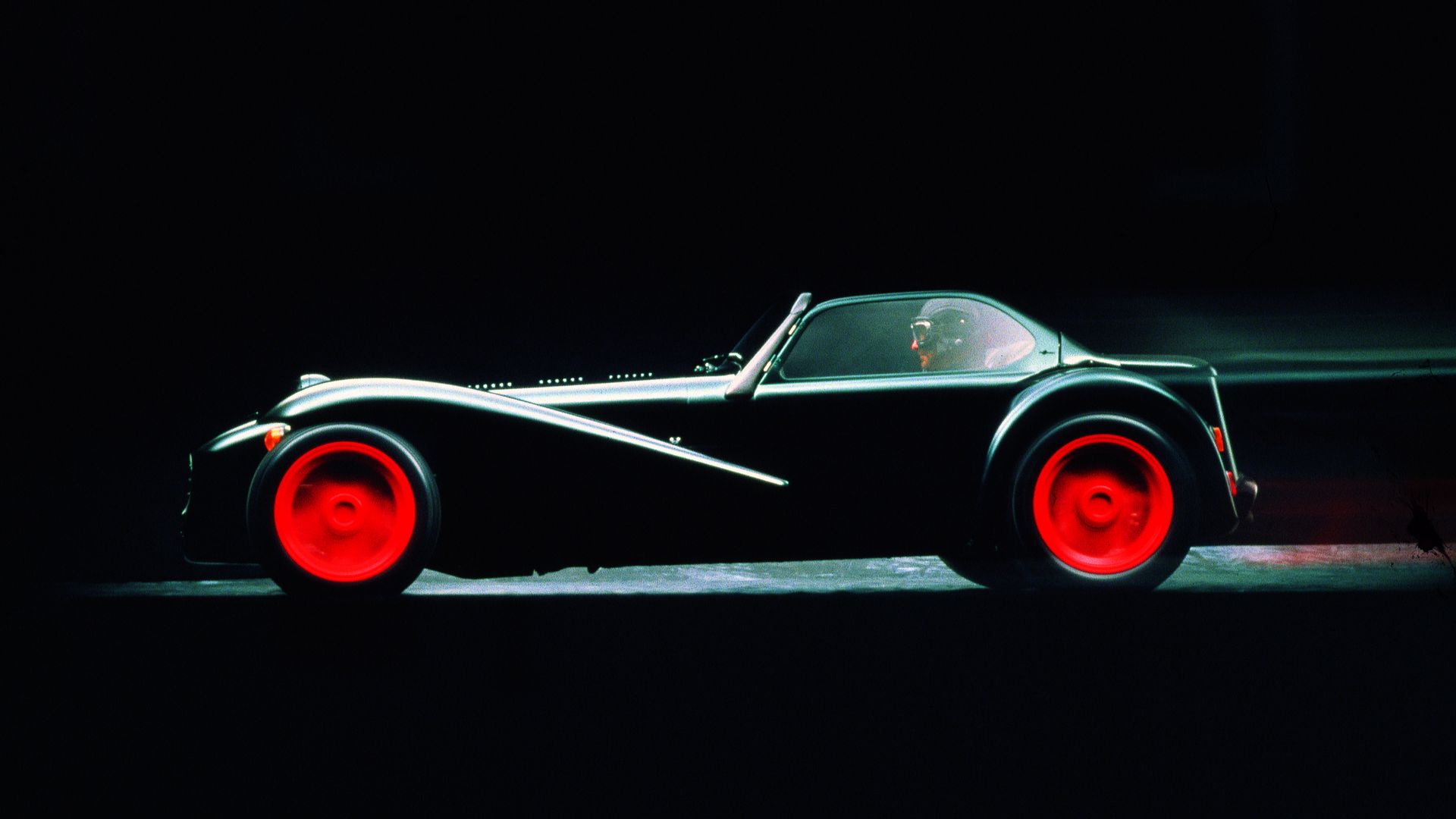 Side view of a black Donkervoort D8 Cosworth with red rims